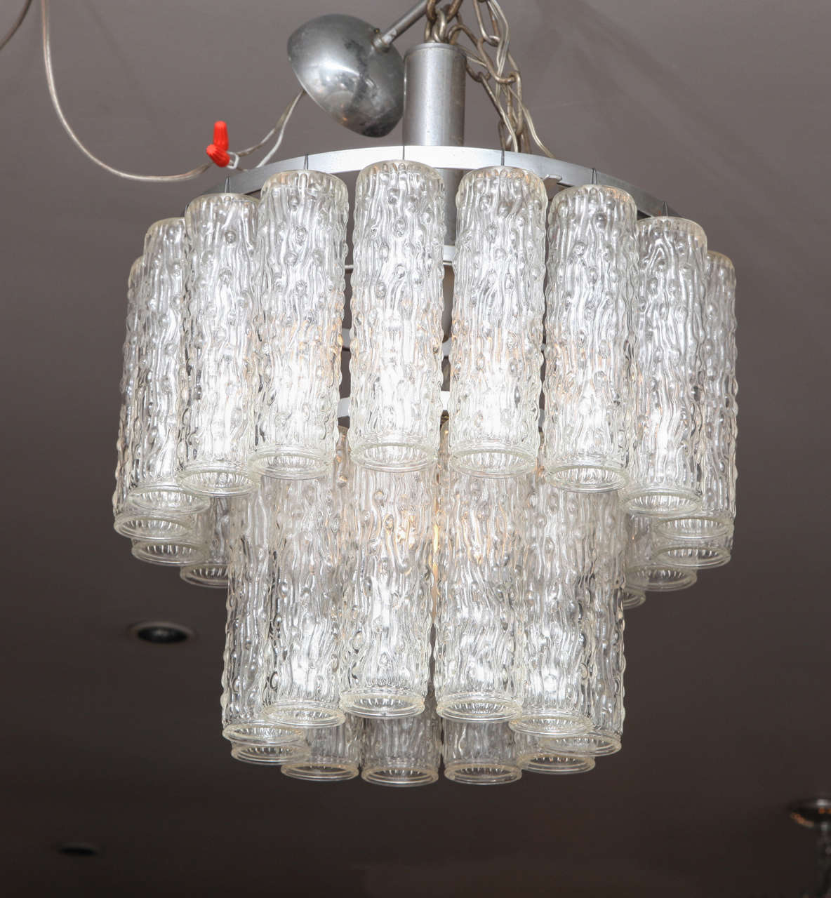 Un grande lampadario italiano di Murano a sospensione a due livelli con pendenti tubolari in vetro scolpito che pendono da una struttura cromata.