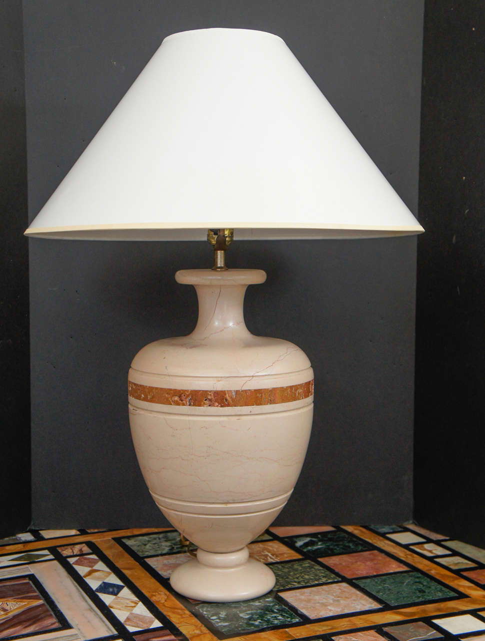 This pair of vintage 1970s Italian table lamps are made from carved travertine that has been inlaid with a rouge marble band. Carved from a solid block the lamps are very substantial and heavy. Travertine a stone favored by the Romans and here used