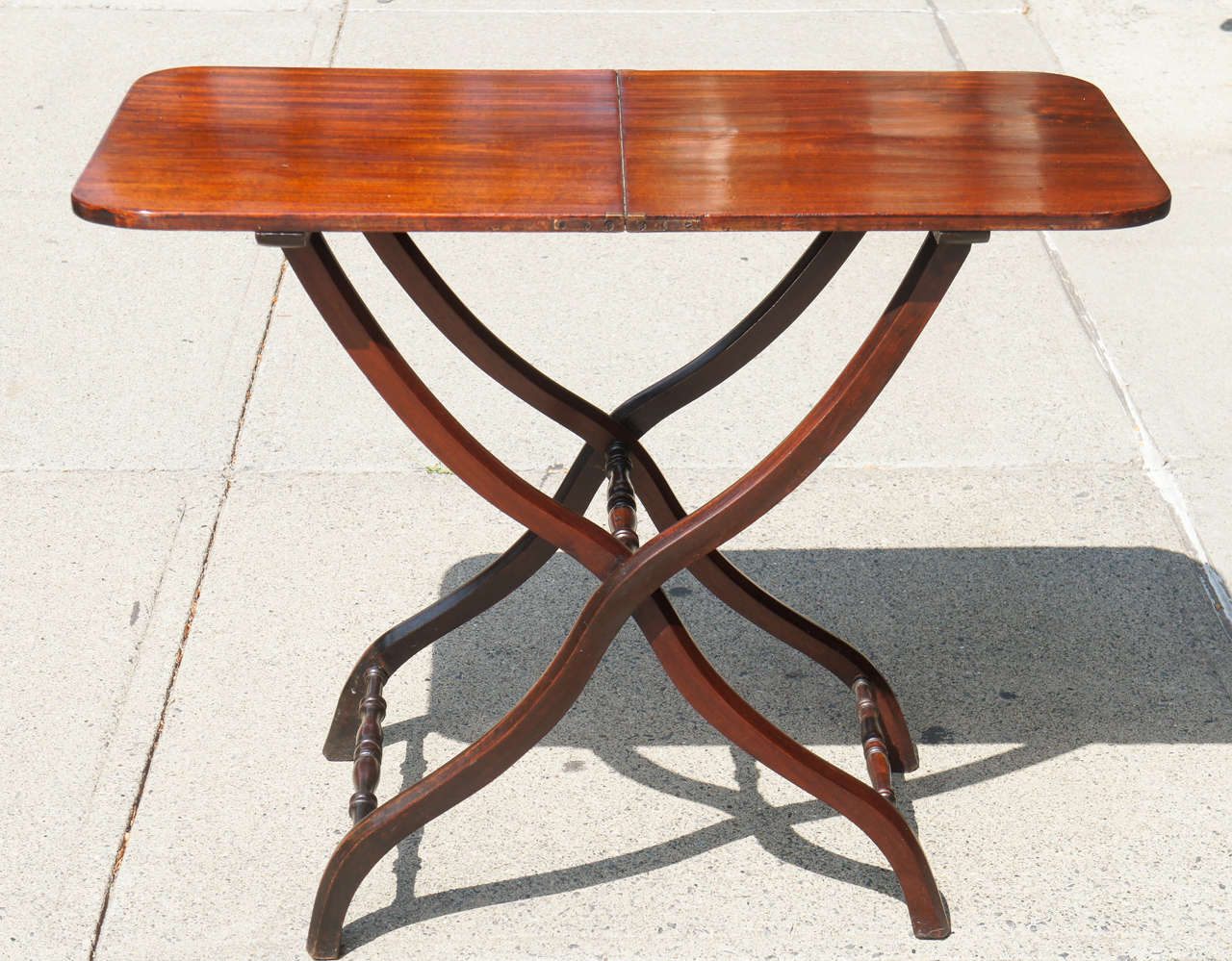 This table intended as a folding coaching table was made circa 1825 in England during the late Regency period. Designed to fold and be stored away the table was used during travel periods for a stable flat surface away from home. Made of