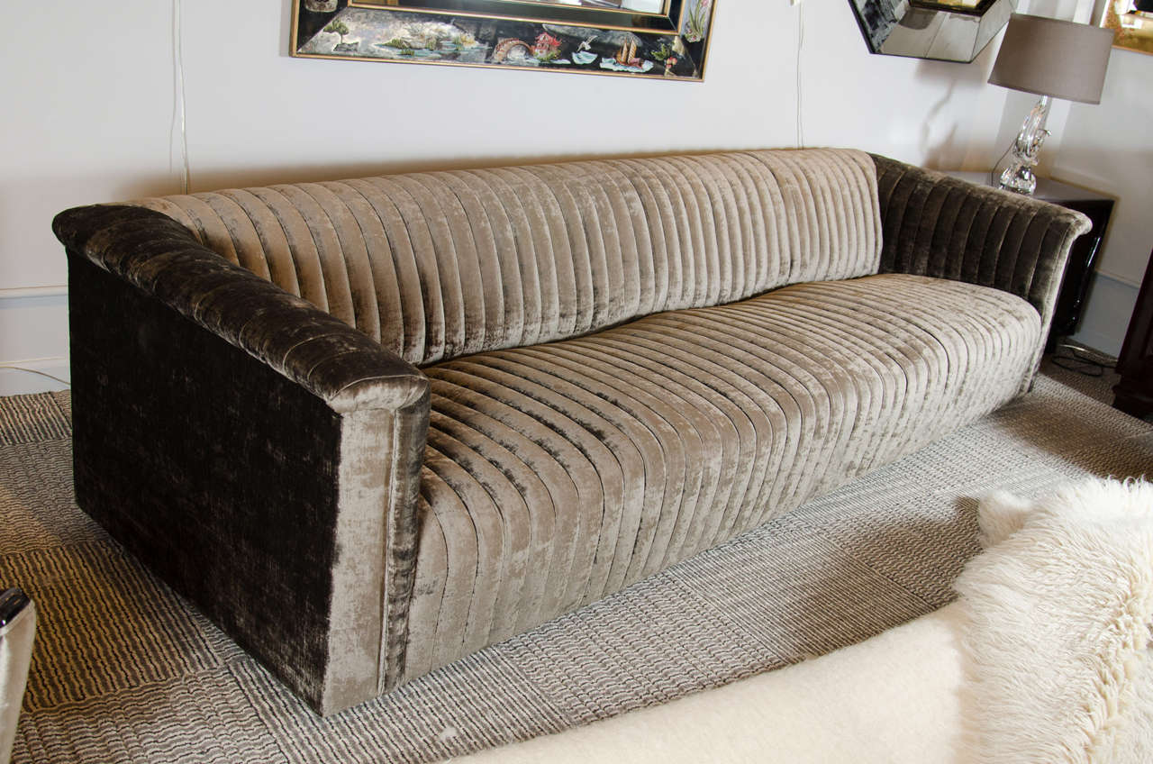 This stunning sofa features a very sleek sophisticated design with all channel back vertical detailing. It has been newly upholstered in smokey platinum velvet and is extremely comfortable as well.