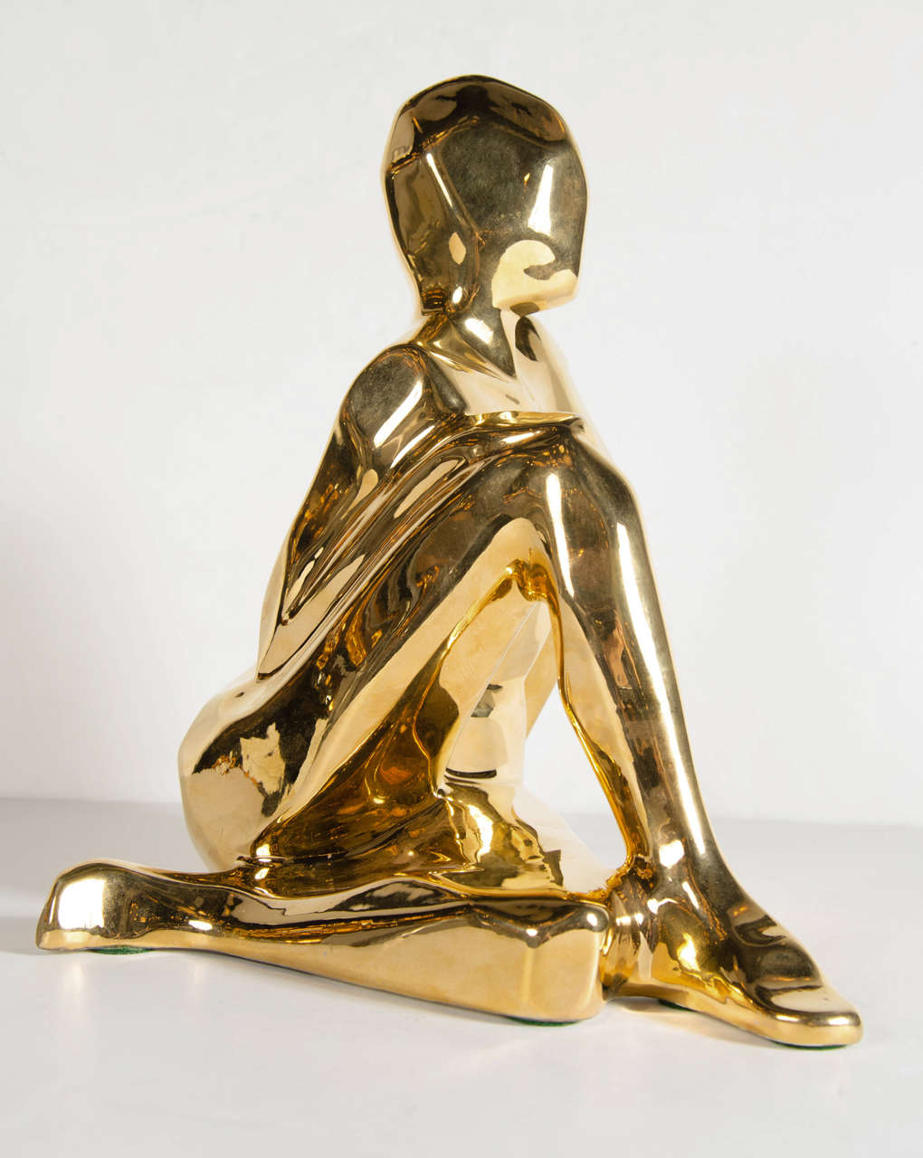 This gold-plated ceramic sculpture features a crouching figurative female sculpture with stylized Cubist form. It bears the name Jaru and dated 1975 on the bottom.