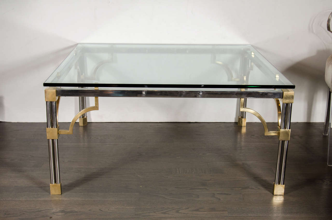 A Mid-Century Modern cocktail table by John Vesey consisting of a brushed nickel frame with geometric brass details. The legs each have four rods bound by brass cube details and has decorative corner supports. The square frame supports a