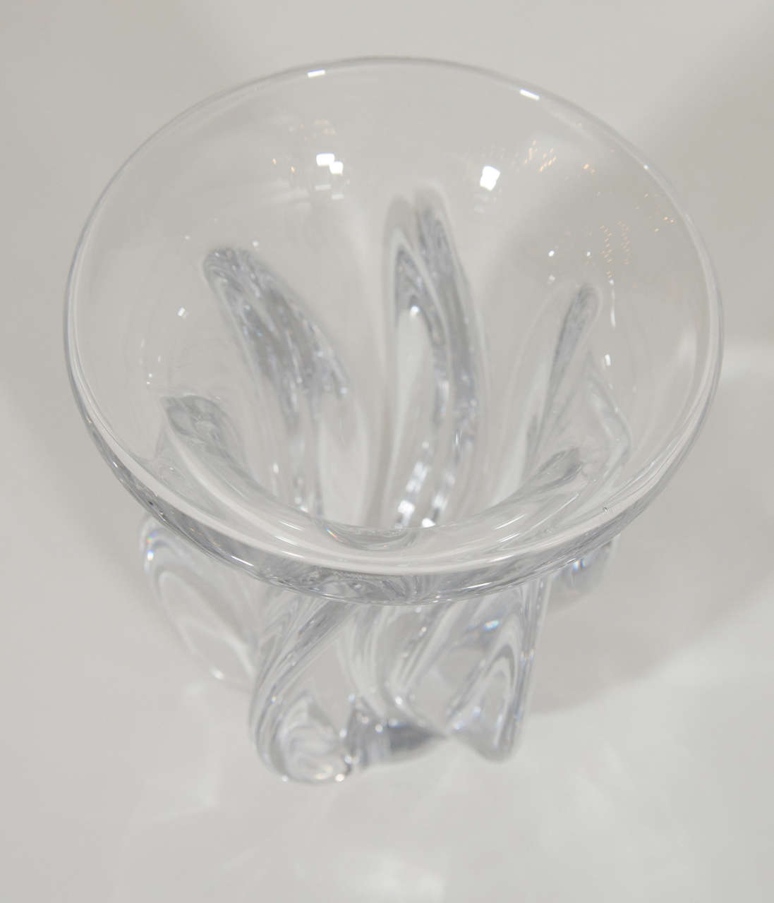 Symmetrical hand blown crystal vase. The body of the vase is a fluted form with a protruding lip and swirled fins design. Creates beautiful patterns of light on any surface. Signed Art Vannes.