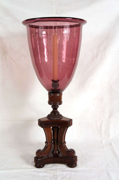 English amethyst-colored glass hurricane on a carved mahogany base.