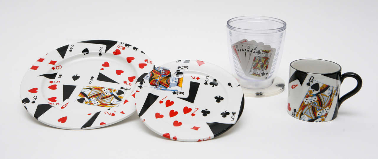A stylish lunch set for four by Gucci, patterned with scattered playing cards. The plates and coasters are marked on the underside 