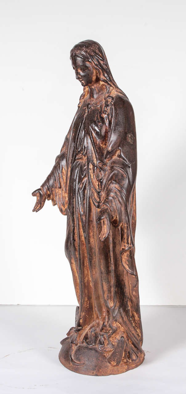 French 19th century cast iron Madonna. A model in pose and in scale with a beautiful draping in the robes clasped with a sacred heart. The Madonna is depicted with refined and soft features and nice lovely flowing hair. The base is 9” round.
29”h x