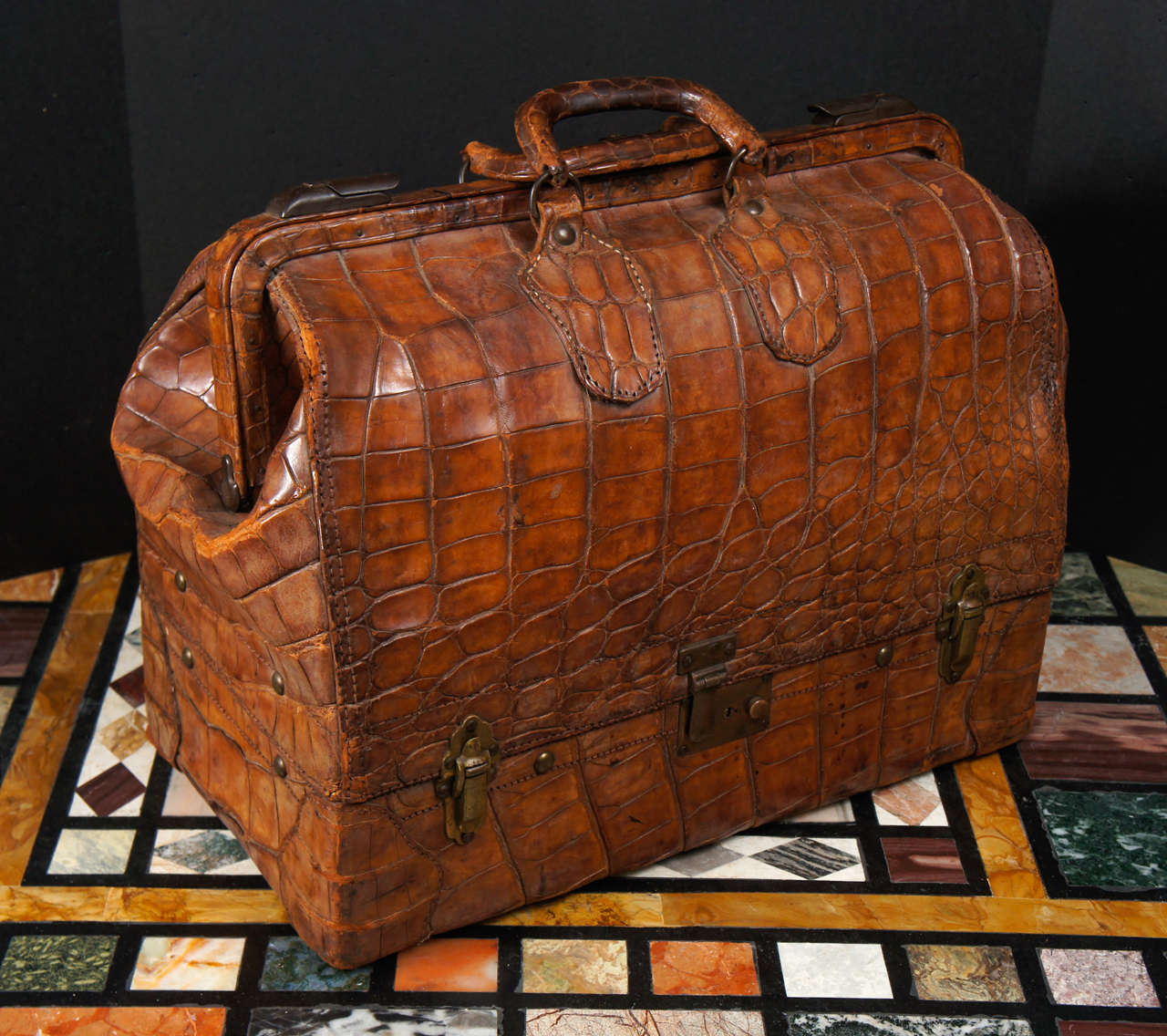 This incredable vintage alligator hide large bag  from the  Edwardian era is a perfect stage prop for magazines or papers. Impractical to use as a carry all or bag its weight and age would make it hard to manage and  all the seams ,locks and handle