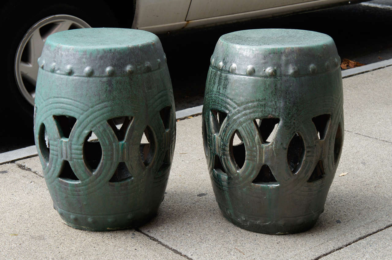 This very good pair of garden stools are chinese and made circa 1900 to 1920. The thick walled body is made of terra cotta and shows all the marks of hand work and the artist tools. Glazed in a very interesting pumpkin textured runny glaze that goes