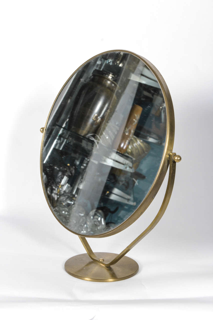 Graceful, adjustable vanity mirror on round base.  France, circa 1970.

Satin brass finish.  One side of mirror is magnifying.

Dimensions:
13.25 inch height
12.25 inch width
4.5 inch depth (base)