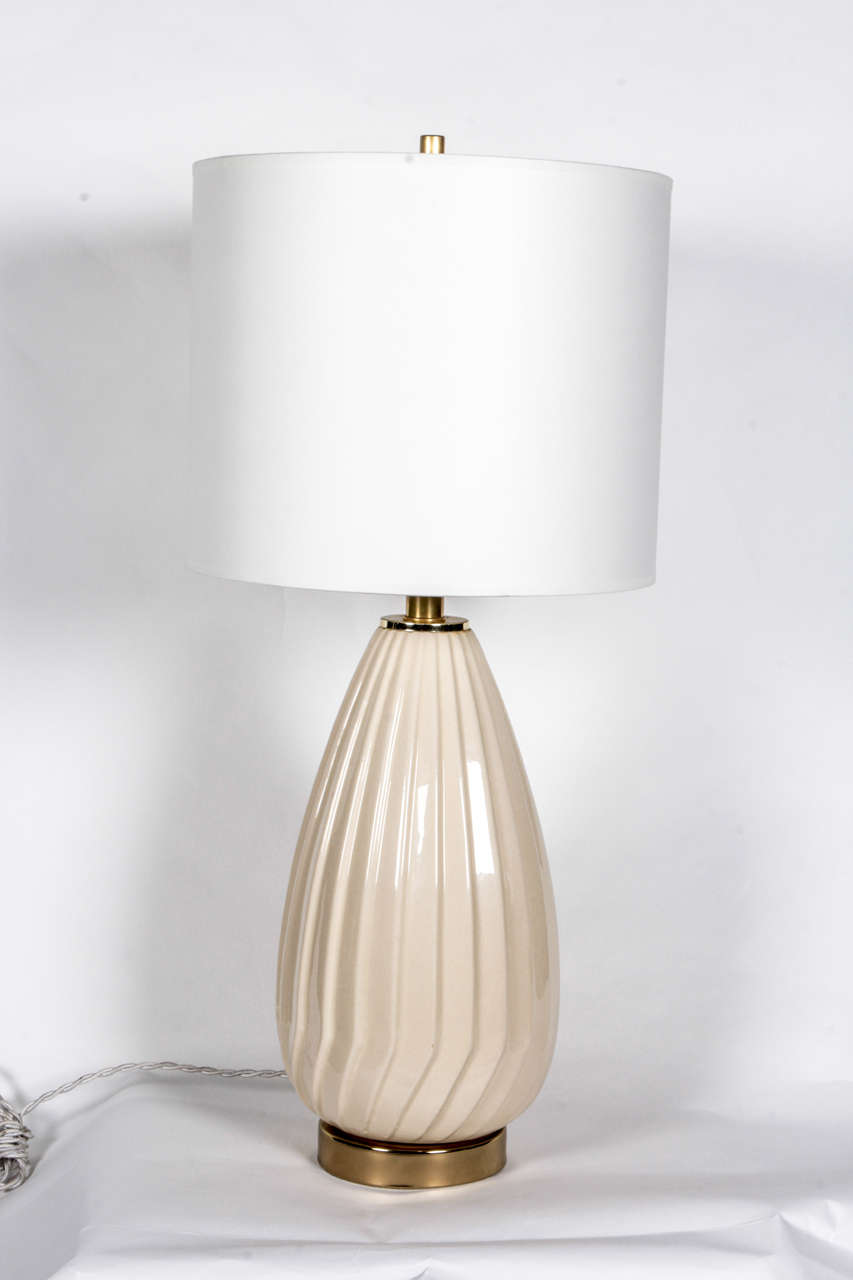 Cream ribbed-glass table lamp with antiqued brass hardware.  Italy, circa 1960.  Rewired for U.S. use; uses one standard U.S.bulb, 75 watts max.  Includes white paper drum shade.

Dimensions:
Height (overall including shade): 25 inches
Height