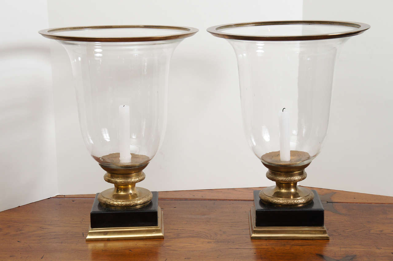Pair of Hurricane lamps, black marble base with brass details.