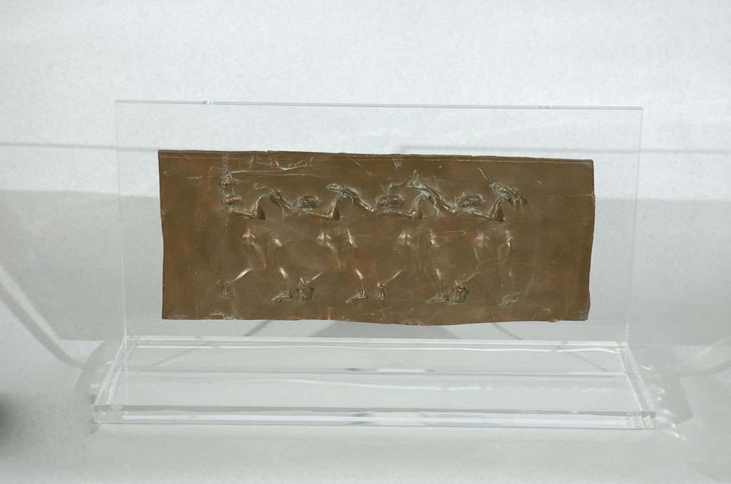 An elegant bronze relief plaque custom mounted on a lucite base titled 