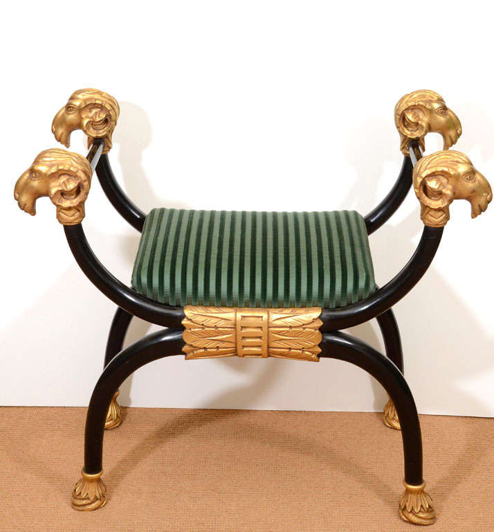 Unusually whimsical lacquer bench with carved, gilt detailing on arms and feet. 

Ram heads top the arms, while hooves adorn the feet, with palm details at the centre support.

Extremely sturdy. Second height is seat height.