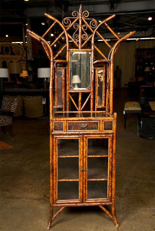 English bamboo cabinet, c. 1880, the top with lacquered panels and a mirror, and the base with a drawer and glass doors, a high quality piece of bamboo furniture.