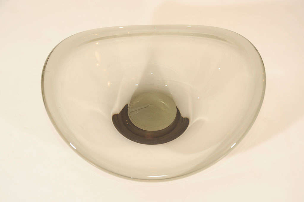 Handblown glass bowl with

amorphous shape, in smoked

grey. Modernist design and

signed Holmegaard.