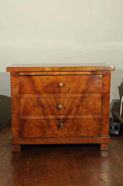 Perfectly proportioned miniature commode with book-matched walnut veneers. (The third drawer locks). From the Restauration period, circa 1820, France.