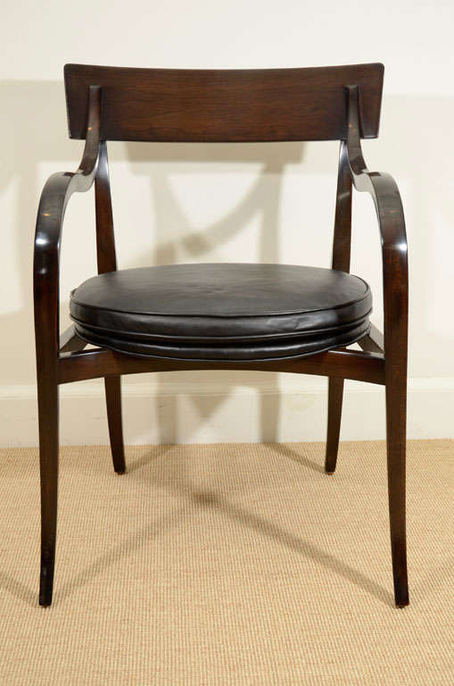 Each with tapering square shaped, curved legs and arms with saber feet, supported a curved back rail and oval upholstered seat.