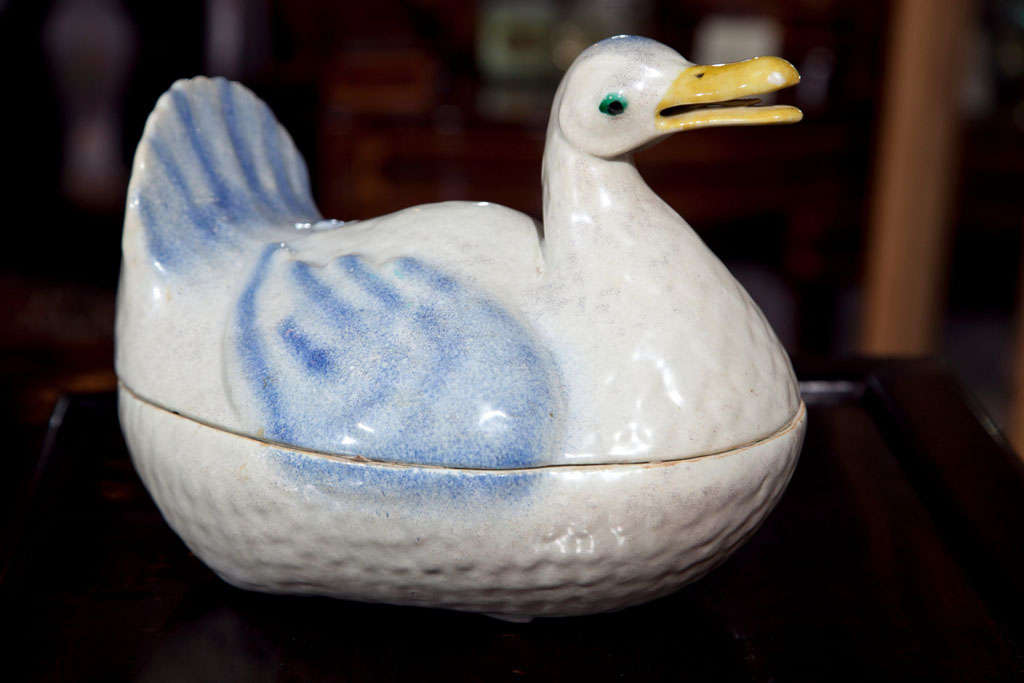 A  WONDERFULLY MODELED DUCK TUREEN IN PALE  BLUE, WHITE AND YELLOW FEET ON THE BOTTOM. THE INTERIOR IS  CRACKLED TURQUOISE