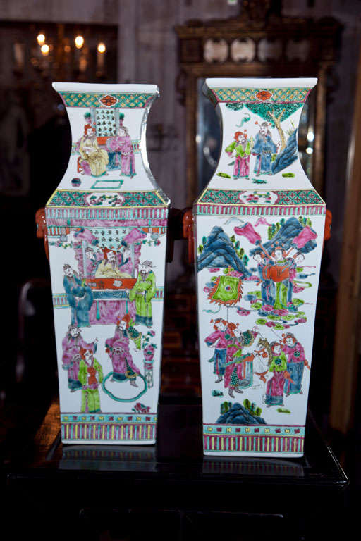 A TALL PAIR OF CHINESE PORCELAIN VASES, HAND PAINTED WITH COURTLY SCENES AND LION FORM MASKS AND RINGS