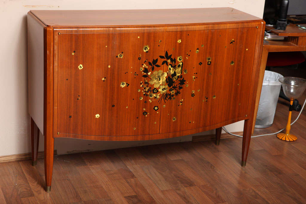 Jules Leleu (1883-1961).

An important rosewood cabinet, decorated with a spray of inlay mother-of-pearl flowers and butterflies, legs with gilded bronze sabots. With the original Maison Leleu label affixed, model number 27849 and dated 1955.
