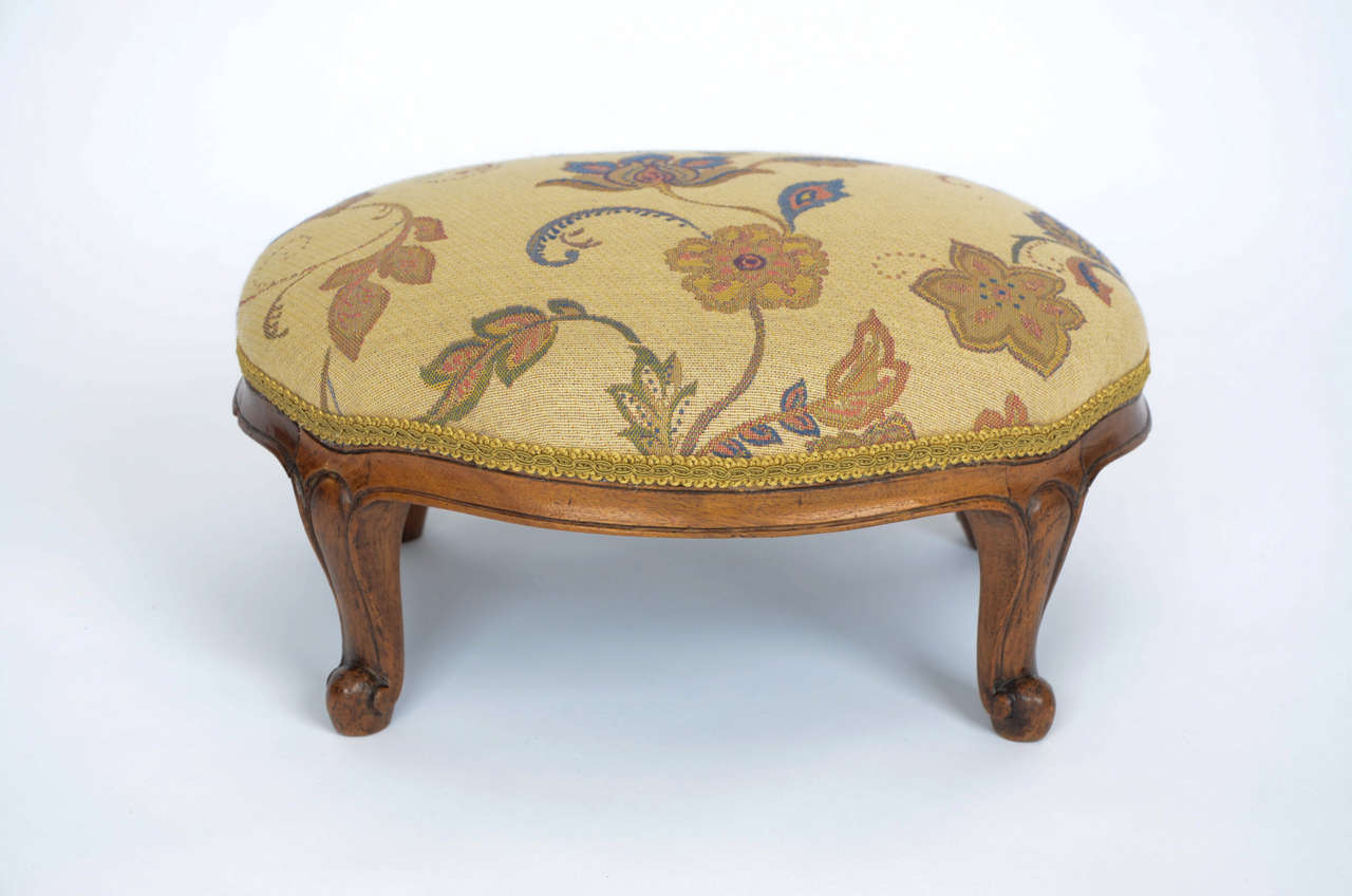 A very good quality English Walnut  Footstool circa 1850

The stool is oval in shape with a walnut frame having four short cabriole legs, typical of the mid Victorian period. The legs and frame have line hand-carved detail.

The stool is over