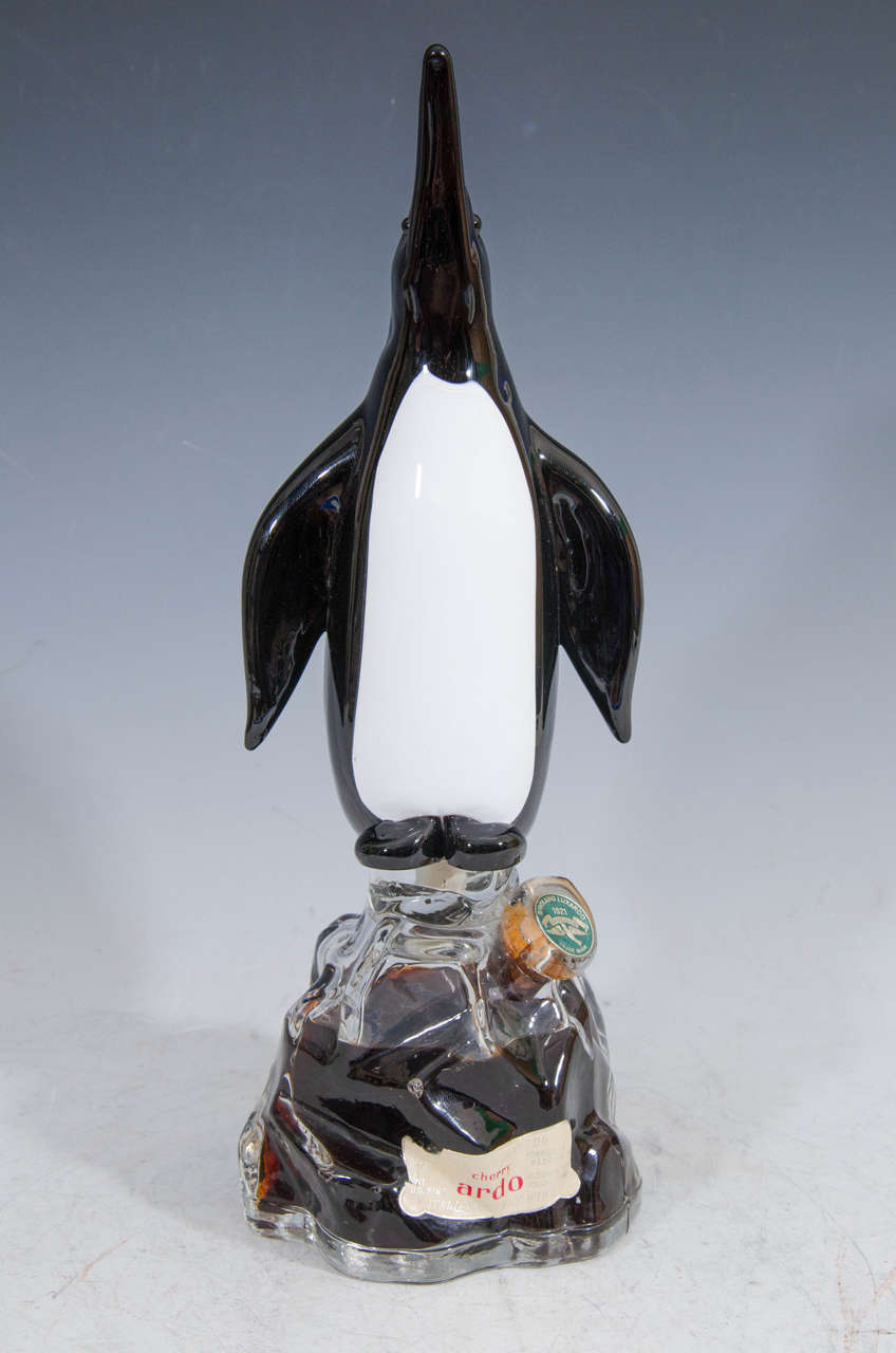 A vintage pair of Italian cherry Ardo wine bottles in the shape of penguins standing on Murano glass iceberg design by Girolamo Luxardo in Torreglia.