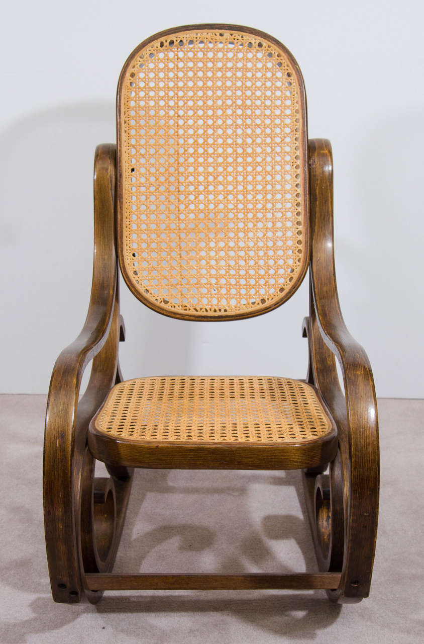 A vintage bentwood child's rocking chair with cane back and seat, circa 1960s.

Reduced from:  $750