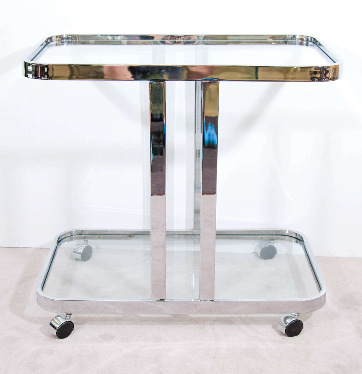 A vintage Milo Baughman flat bar chrome and glass bar cart on casters.

Good vintage condition with age appropriate wear. Some minor scratches.