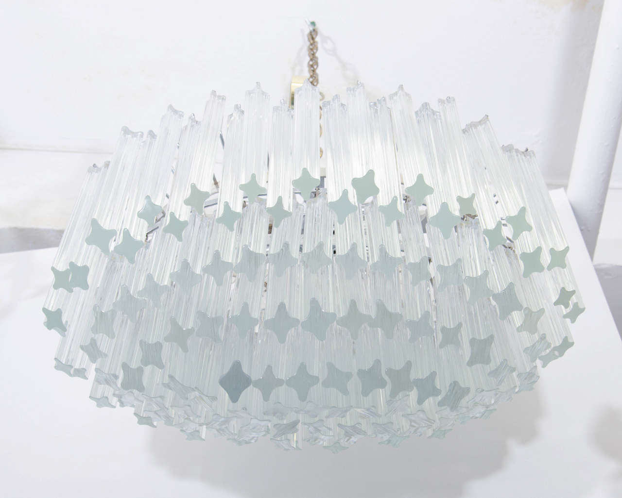 A vintage chandelier by Venini composed of clear glass rods suspended in tiers from a metal frame.

17