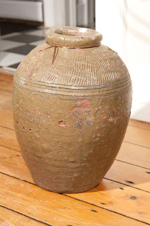 This lovely glazed terracotta rice wine storage pot was bought in the Perigord (Southwest France), but originated in China. With an unusual olive-brown glazing and striated collar, this pot would make a great large vase or a bubbling water feature