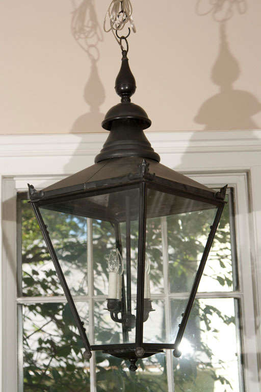 This classic black painted copper street lantern has great proportions and an elegant presence with an unusual bottom finial. Fully restored and wired for the U.S. with antiqued brass fittings, it is the perfect hanging piece to grace a hallway or