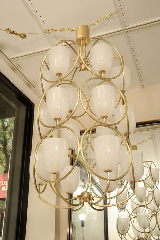 Large scale brass chandelier featuring white glass shades In Excellent Condition In New York, NY