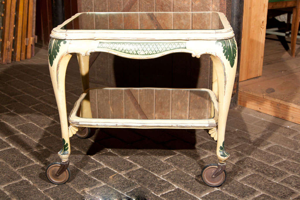 Yellow and green painted and gilt Italian tea cart on large wheels with two mirrored surfaces.