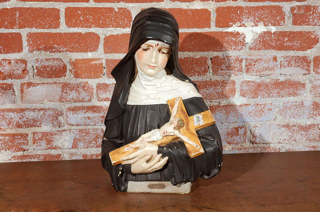 A vibrant chalkware bust of one the Catholic Church's most popular saints; St. Rita of Casia, the patron saint of lost and improbable causes. Chalkware is made of sculpted gypsum and was popular between the late 18th century and the 1930’s.<br