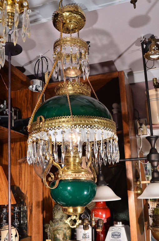Rare Victorian Green cased glass shade and font parlor lamp, created in the Aesthetic style, originally kerocene, features a shade fitted with a brass ring, dressed with facet cut crystal spears, in beautiful restored condition. Circa 1880's  Item
