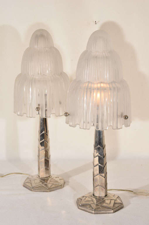 French Art Deco table lamps, architecturally inspired with sky scrapper styling that dominated this movement in France and America in the 20's.   Though not signed, the molded glass shades represent the work of Rene' Lalique or Sabino.    The bases