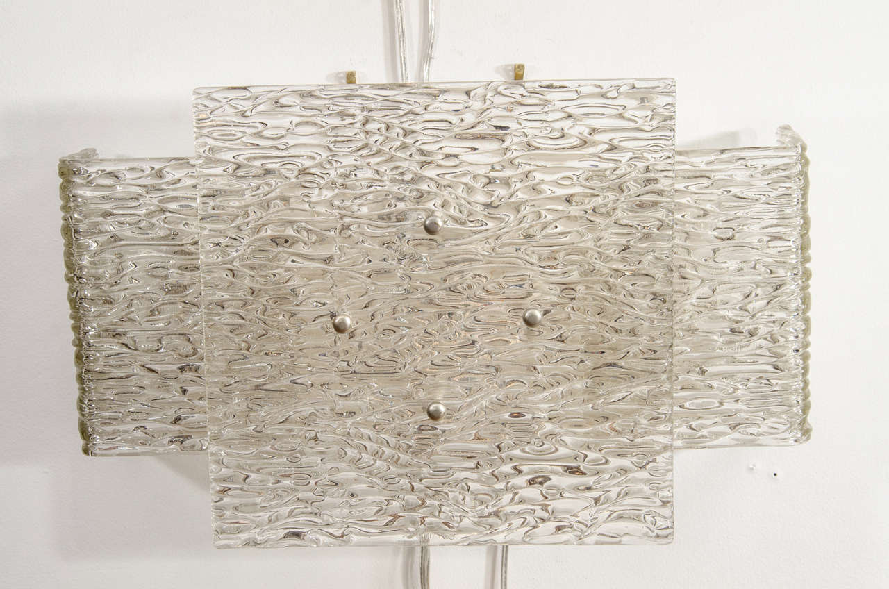 Pair of overlapped, textured glass sconces with nickel finial detail by Kalmar.

View our complete collection at www.johnsalibello.com