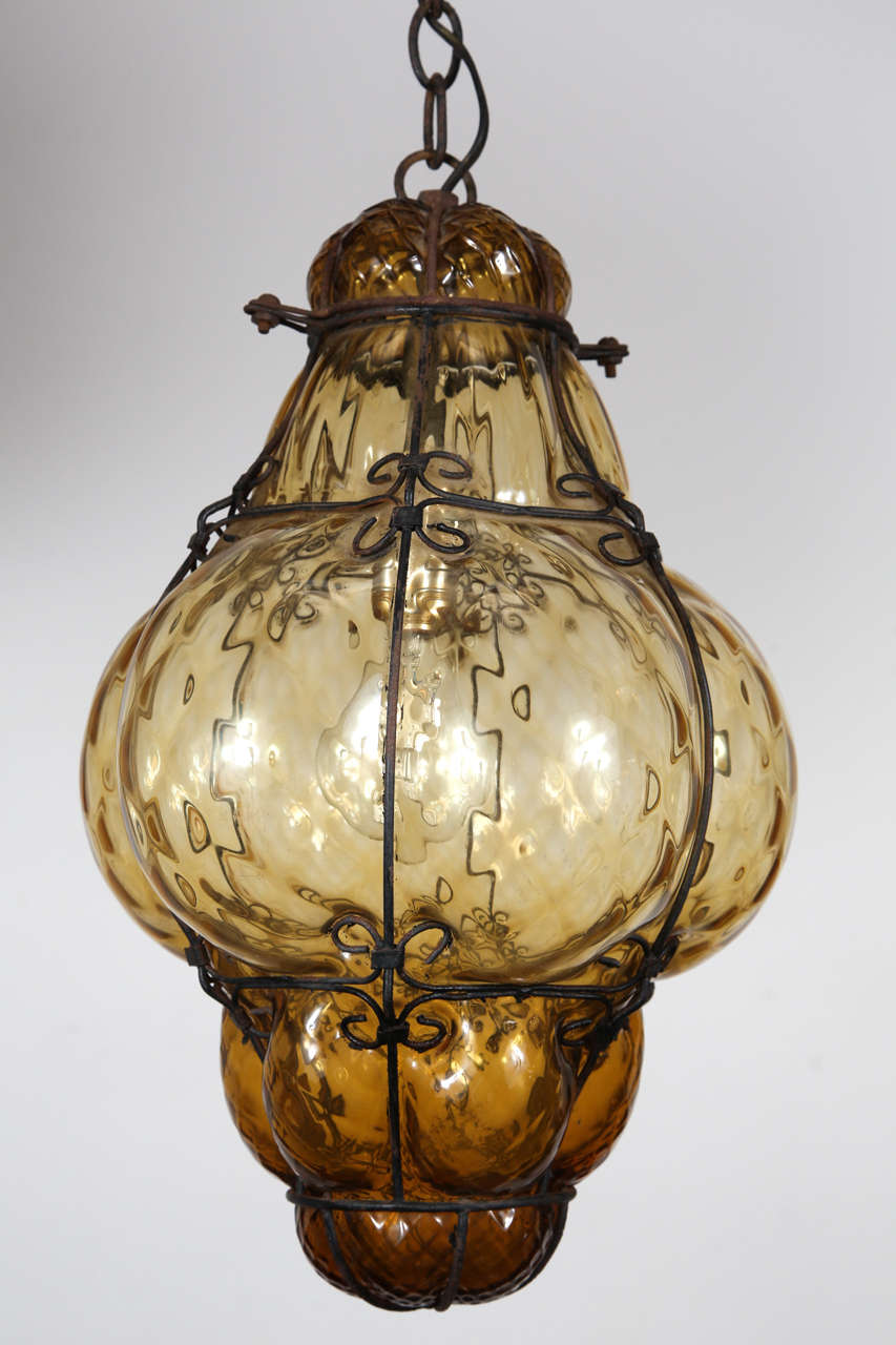 Gorgeous vintage Seguso Murano bubble wire wrapped amber glass cage pendant light. Glass is hand blown with amber tint.
1940 Seguso Murano bubble glass cage lantern or pendant, Oriental Ali Baba style.
It has a 