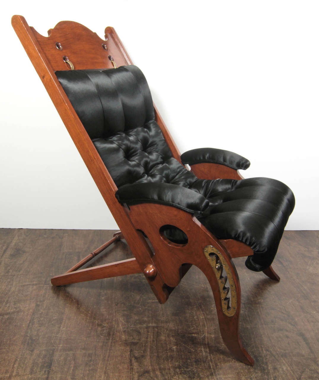 An Edwardian-style deckchair for a yacht in mahogany and brass with buttoned upholstery. The chair was one of several made in France for the Paris decorator, furniture designer, and antiques dealer Jean-Pierre Hagnauer, who sold a pair to Arturo