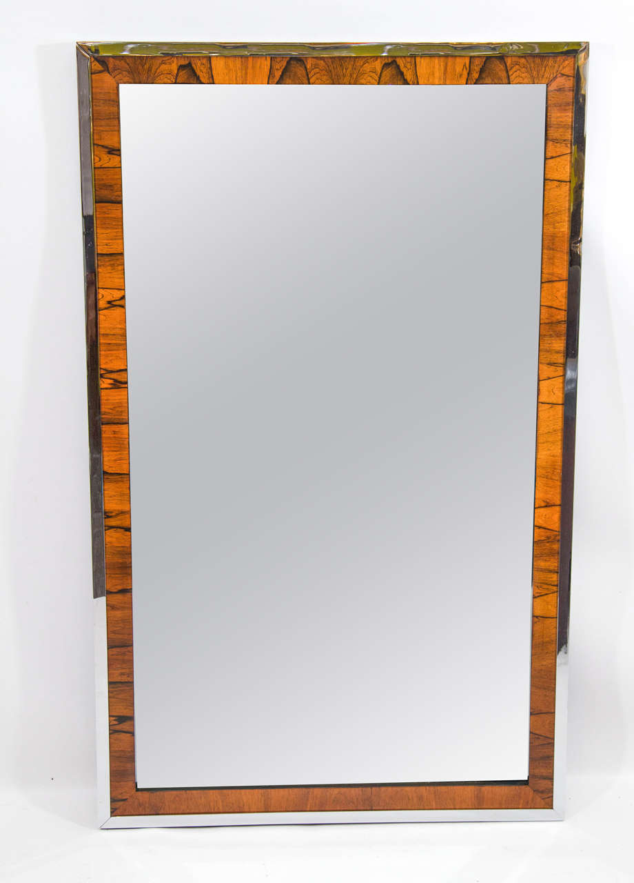 Handsome and crisp wall mirror framed very nicely in a rosewood surround and chrome. Please contact for location.