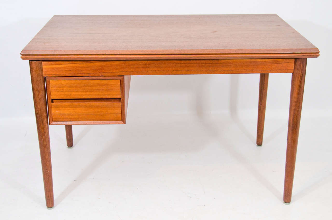Danish teak desk with reversible drawers that can be moved left or right to your preference. The top folds and can open for a broad surface suitable for a work or dining table. Please contact for location.