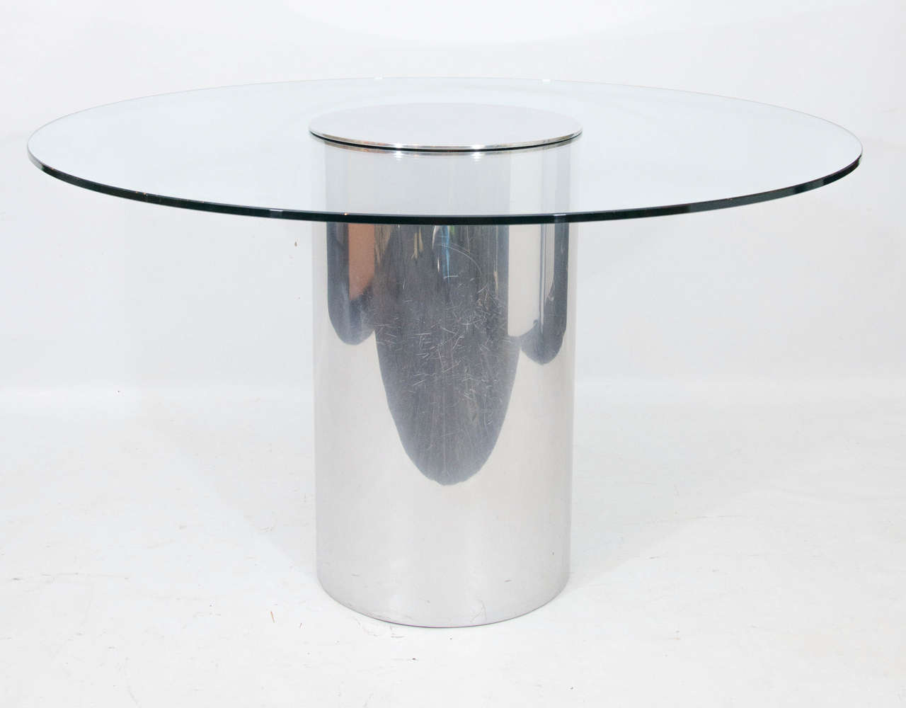 Minimalist modern designed dining table with a polished aluminum pedestal and an integrated glass tabletop. Please contact for location.