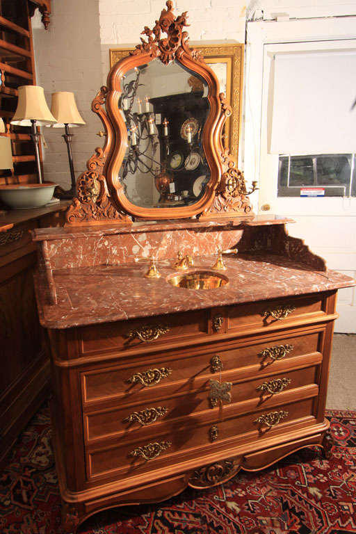 Custom marble top bath vanity with gilt sink.