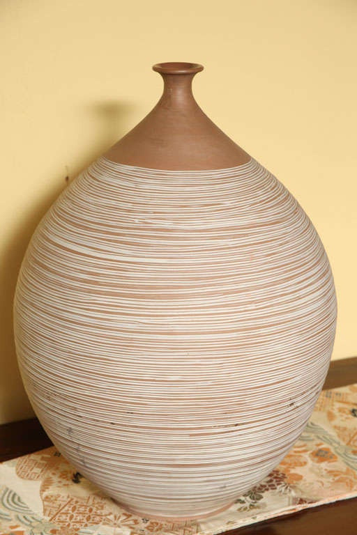A large 20th century ceramic vase with hand cut pattern from the Thai Prem collection. This limited production vase showcases a large belly below a very narrow neck. The vase features a white hand cut horizontal striated pattern, except on the neck,