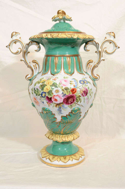 We are pleased to offer this large green Victorian vase painted in the exuberant High Victorian style. Made circa 1880 the artist blended well painted flowers, a sea foam green ground, and elaborate rococo handles to give the vase a unique Victorian