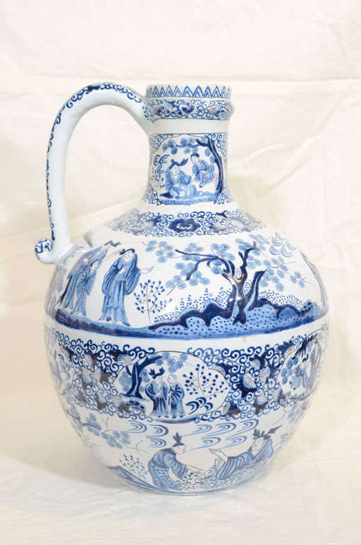 Provenance: From the collection of Katherine Mellon
Painted beautifully with bands of garden scenes and chinoiserie figures separated by horizontal bands of flowers and vines.
The bottom of the jug shows the mark of De Klaauw (The Claw).