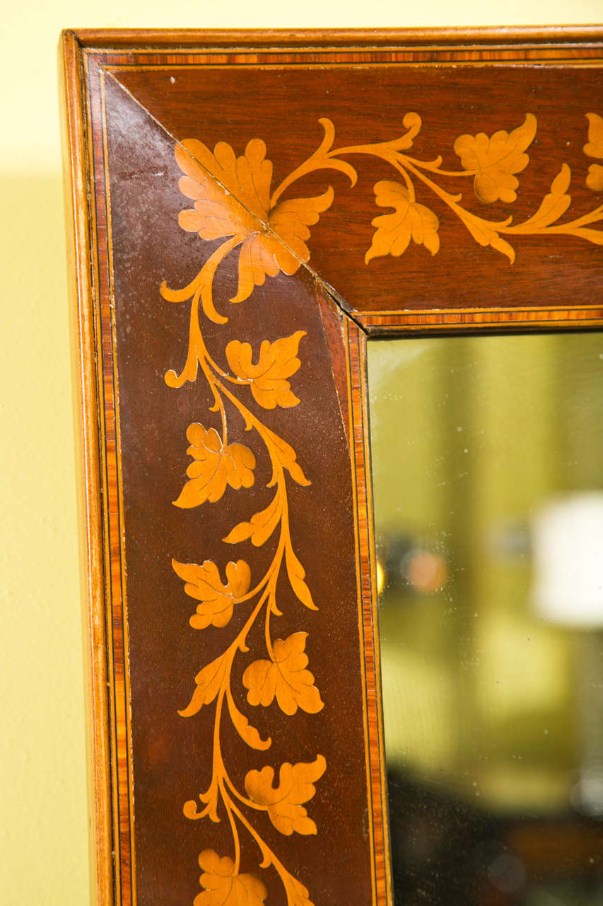 Pair of rosewood and satinwood inlaid mirrors in the Adam's style, depicting beautiful leafy detail; one has clear glass and the other more distressed.