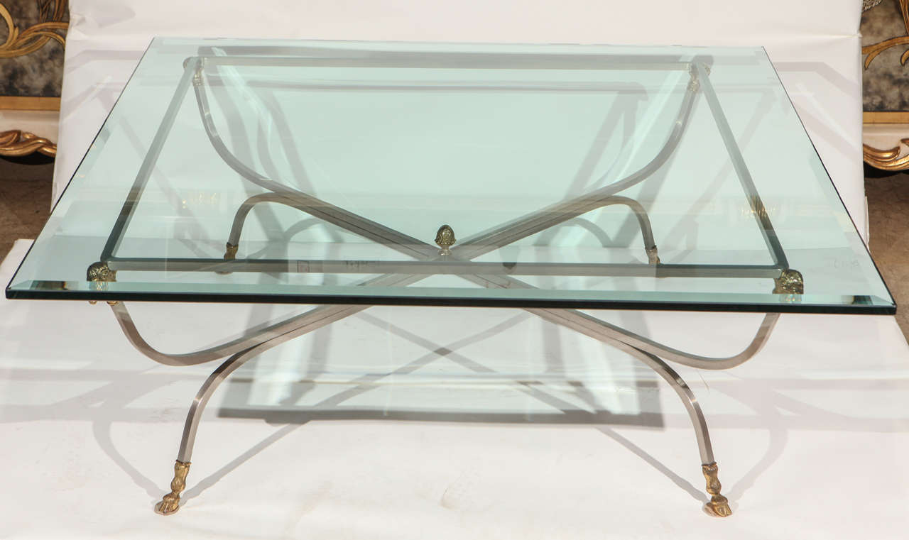 A vintage brushed steel and brass ram's head coffee table in the manner of Maison Jansen. Table has brass hoofed feet. Original 5/8
