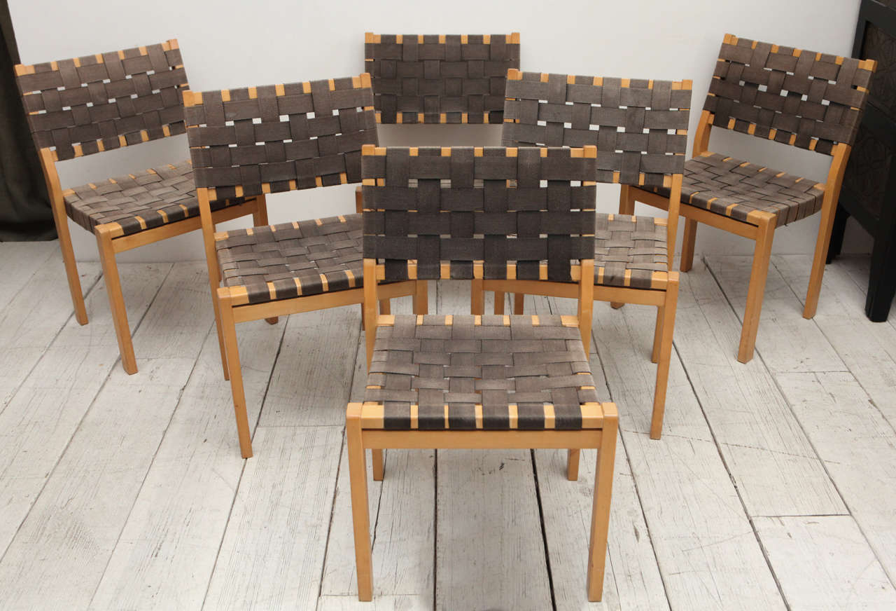 Six dining chairs with faded grey woven seats and back.
