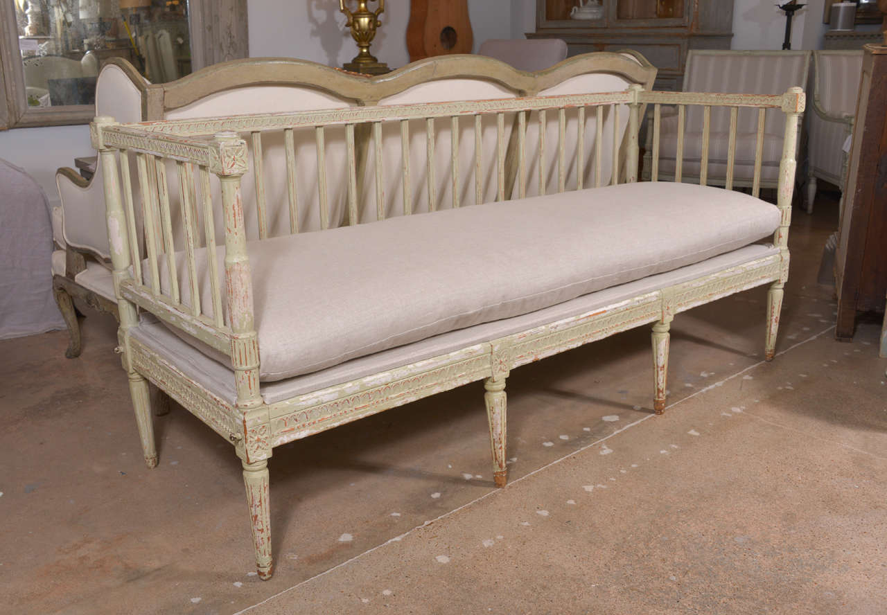 Early 19th century Swedish bench with back and sides, newly upholstered in linen with a seat cushion.
